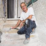 Norbert Hoepfer in Tel Aviv auf einer Treppe mit Terrazzo-Blockstufen in einem Wohnhaus vom Ende der 1920-er Jahre. Foto: Stefanie Järkel dpa