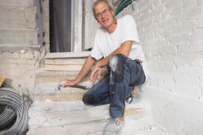 Norbert Hoepfer in Tel Aviv auf einer Treppe mit Terrazzo-Blockstufen in einem Wohnhaus vom Ende der 1920-er Jahre. Foto: Stefanie Järkel dpa