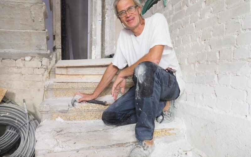 Norbert Hoepfer in Tel Aviv auf einer Treppe mit Terrazzo-Blockstufen in einem Wohnhaus vom Ende der 1920-er Jahre. Foto: Stefanie Järkel dpa
