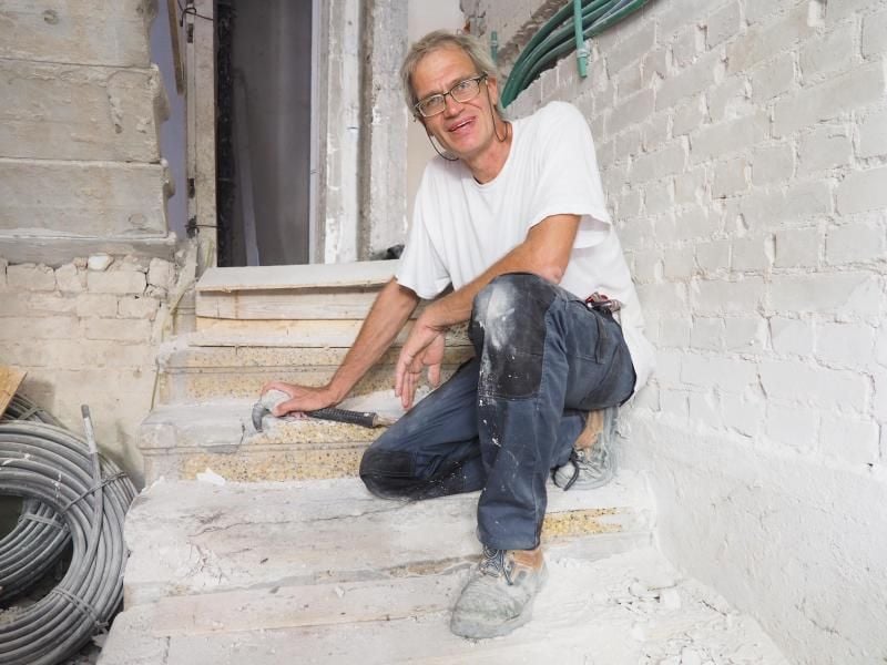 Norbert Hoepfer in Tel Aviv auf einer Treppe mit Terrazzo-Blockstufen in einem Wohnhaus vom Ende der 1920-er Jahre. Foto: Stefanie Järkel dpa